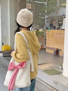 Winter style white plush fleece tote bag with a red checkered bow and casual outfit