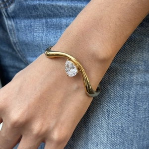 Minimalistischer 18K Gold Wellenarmreif mit einem großen weißen Zirkonstein