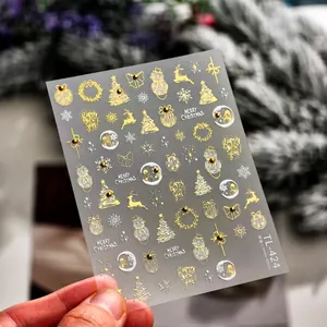 Macro detail of Christmas nail stickers with gold reindeer and snowman patterns TL-424