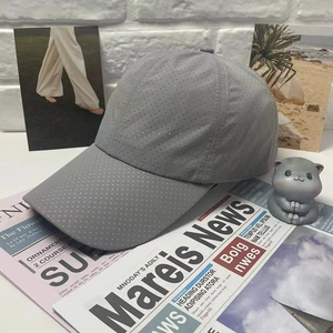Breathable gray baseball cap on newspapers with a cute cat plush toy for outdoor sport