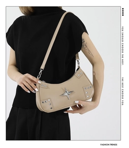 Detail of beige PU leather shoulder bag featuring silver rivets and star metal accessory