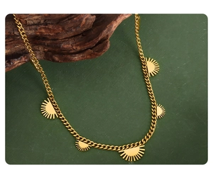 Detail of 18K gold-plated titanium sunburst pendants on a classic Cuban link chain