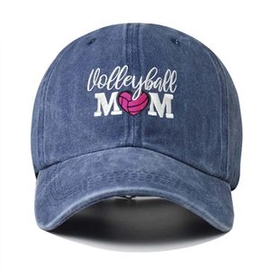 Close-up of Volleyball MOM embroidery and pink heart on washed denim baseball cap