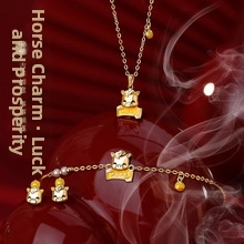 Detail of gold necklace and bracelet with cartoon horse pendant and carnelian beads