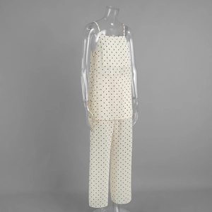 Detailed view of the polka dot texture and fabric on a white camisole and pants set