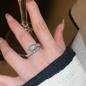 Close-up of a silver snake-shaped open ring with sparkling white cubic zirconia on a hand