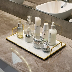 Golden metal rectangular tray with white marble base for bathroom countertop organization