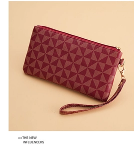 Detail view of wine red geometric pattern wallet with gold zipper and wrist strap