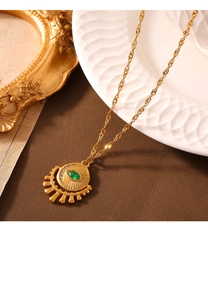 Detail of vintage sunburst pendant with green marquise zircon on gold water wave chain