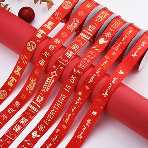Detail of red festive ribbons with gold printed Chinese and English holiday blessings
