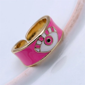 Macro shot of adjustable gold ring featuring a bright pink enamel evil eye detail