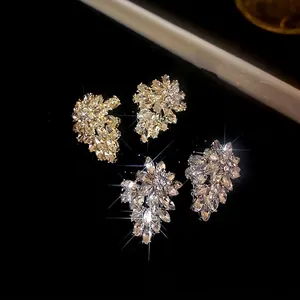 Sparkling crystal leaf stud earrings set with marquise-cut stones on a black background