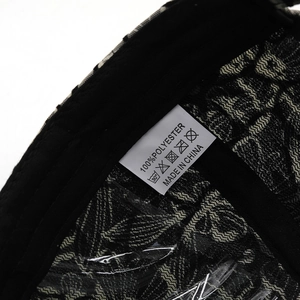 Detail shot of the white wash care label on black floral lace fabric 100% polyester