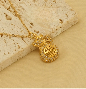 Dettaglio macro del ciondolo a sacchetto portafortuna in oro 18k con cristalli su acciaio