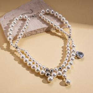 Double-layered pearl necklace featuring a blue teardrop pendant and silver spheres