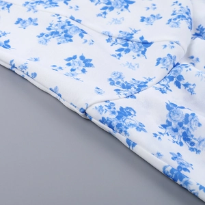 Dettaglio macro del tessuto in chiffon bianco con elegante stampa floreale blu