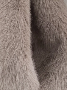 Detailed macro view of the fluffy taupe faux fur texture and soft fiber density