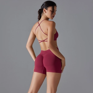 Detail of burgundy yoga set featuring cross-back bra and high-waist scrunch butt shorts