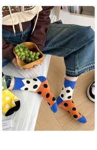 Detail of knitted mid-calf socks with colorful polka dots in a cozy indoor setting