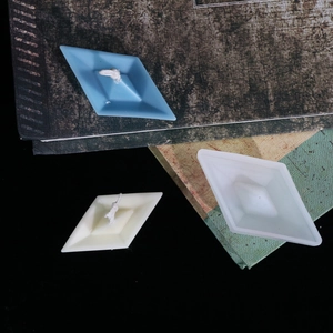 Makro-Detail von Papierschiffchen-Silikonform und fertigen Duftkerzen auf Vintage-Büchern