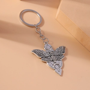 Gothic silver moth keychain with skull and moon phases on a minimalist background