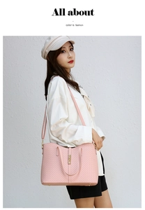 Détail du sac cabas rose tressé avec une finition texturée et un fermoir doré chic
