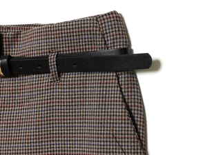 Detailed macro view of houndstooth fabric with a black leather belt accessory