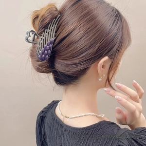 Detail of angel wing hair claw clip with purple stones and crystals on hair