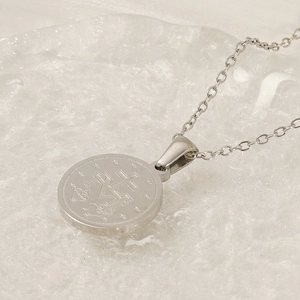 Macro detail of silver religious medallion pendant with sacred heart and star engraving