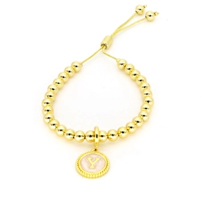 Detail van verstelbare gouden kralenarmband met een ronde hanger met de initiaal letter Y