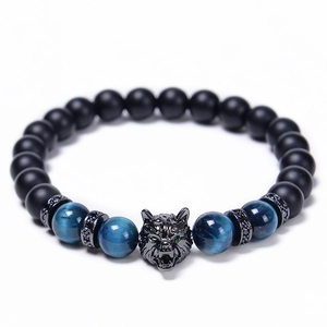 Detail of wolf head bracelet with blue tiger eye stones and matte black agate beads