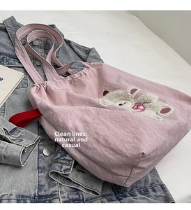 Pink canvas tote bag featuring a 3D plush lamb patch and a red webbed handle strap