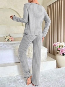 Detail of grey ribbed knit pajama set with black lettuce edge trim on sleeves and pants