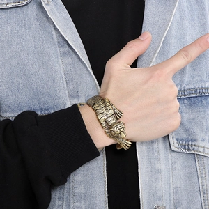 Detail of vintage gold tiger head bracelet on a male model wearing a denim jacket