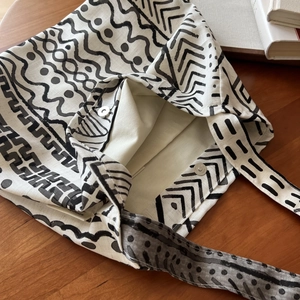 Detail of silver magnetic closure and hand-drawn geometric print on linen tote bag