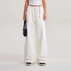 Detail view of cotton wide-leg joggers with high waist drawstring and cross embroidery