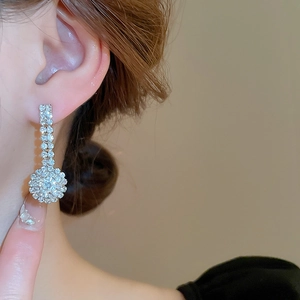Close-up of elegant silver bow tie earrings with sparkling pavé zircons on a model