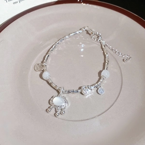 Detail of silver beaded bracelet with oval gemstone lock pendant and Fu character charm