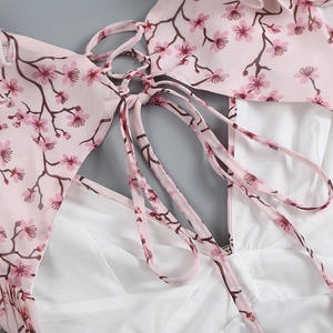 Détail d'une robe en mousseline fleurie avec laçage au dos et imprimé cerisier rose