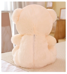 Detail of the back zipper design on a soft cream plush teddy bear toy on a bed