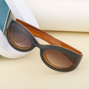 Close-up of Y2K oval cycling sunglasses with orange inner frame and size details
