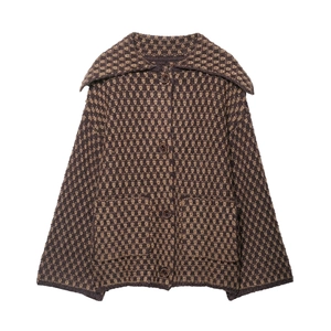 Détail macro du motif en maille à carreaux et des boutons sur un cardigan à col polo