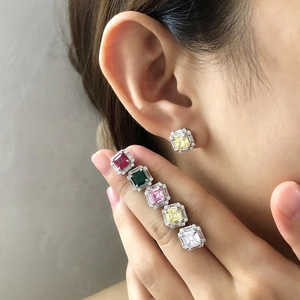 Detailed view of colorful square cut gemstone stud earrings with micro-diamond halo