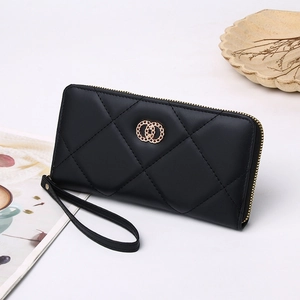 Close-up of black quilted long wallet featuring gold double-ring logo and wrist strap
