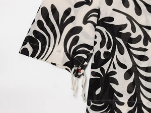 Detail of floral kimono sleeve with cotton linen texture and red bead drawstring