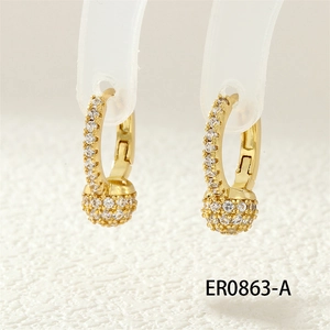 Detailed close-up of gold hoop earrings featuring a micro-paved sparkling crystal ball
