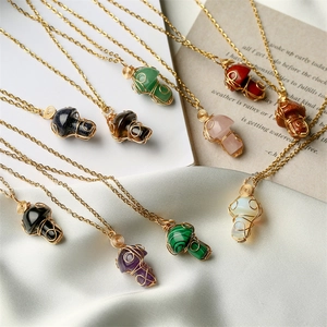 Detailed wire-wrapped natural crystal mushroom pendants on gold chains over silk and book