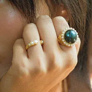 Detailed view of vintage S925 silver rings with large labradorite and pearls on finger