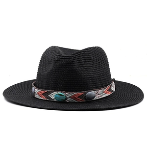 Détail d'un chapeau de paille noir avec ruban brodé bohème et perles turquoise