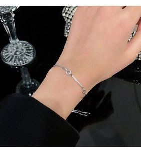 Detailed view of silver charm bracelet featuring cubic zirconia floral and circle accents